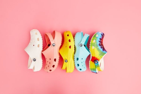 A rainbow row of clogs on pink